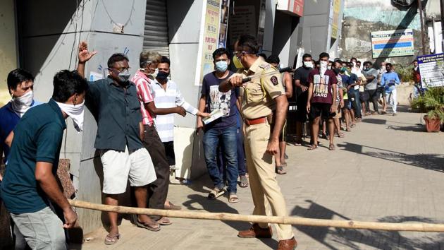 Police personnel baton charge on people violating social distancing while purchasing liqour outside a wine shop in Mumbai. (ANI) Police personnel baton charge on people violating social distancing while purchasing liqour outside a wine shop in Mumbai. (ANI)