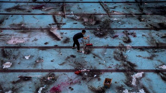 A man clears debris following the clashes between police and anti-government protester after a two-week campus siege of the Polytechnic University in Hong Kong, China, November 16, 2019. Reuters has been awarded the 2020 Pulitzer Prize in Breaking News Photography for Hong Kong protests. (Adnan Abidi / REUTERS)