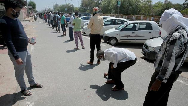 A buyer draws circle for social distancing rule for corona pandemic in the queue outside a liquor shop, in Jaipur on Tuesday, May 5, 2020.(Photo: Himanshu Vyas/ Hindustan Times) A buyer draws circle for social distancing rule for corona pandemic in the queue outside a liquor shop, in Jaipur on Tuesday, May 5, 2020.(Photo: Himanshu Vyas/ Hindustan Times)
