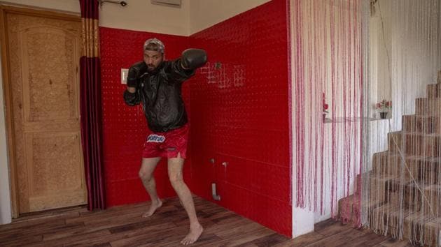 Wushu champion Aijaz Hassan practices inside his home in Srinagar. “Last year I was able to do my practice at the indoor stadium near my home. But this year the lockdown has forced me and many others like me to practice at home,” Hassan told AP. Srinagar’s lone indoor stadium has been converted into a quarantine centre. (Dar Yasin / AP)