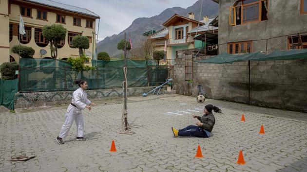 Football coach Qudsiya Altaf (R), and her sister Kabra Altaf, a judo champion, practice inside a school compound that belongs to their father, near their home in Srinagar. The sisters are restricted to their neighbourhood but the lockdown is nothing new. (Dar Yasin / AP)