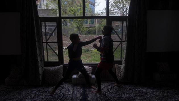 Wushu artist Aliza Shah (L), spars with her sister Kaifa Shah inside their home in Srinagar. Going out for practice is too high a risk but the athletes’ priority remains to keep fit. (Dar Yasin / AP)