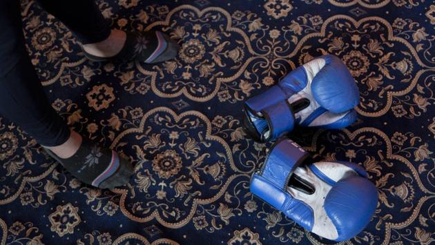 Eyed Akeel Khan’s boxing gloves lie on the floor of the room where he practices at home in Srinaga. The carpet in his room has replaced the boxing ring. (Dar Yasin / AP)