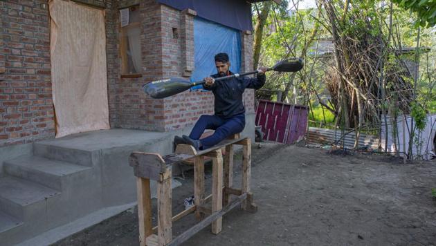 Kashmiri kayaker Vilayat Hussain practices on a rugged under-construction wooden ergometer at his home on the outskirts of Srinagar. Like many other athletes, the coronavirus pandemic has restricted Hussain to his home. “It (the wooden ergometer) helps me to maintain my workouts even though it is far from what it should look like,” Hussain told AP. (Dar Yasin / AP)