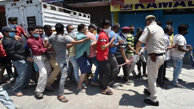 Police try to control the crowd as people stand in a queue, flouting social distancing measures, to buy alcohol in Delhi on Tuesday. (PTI Photo) Police try to control the crowd as people stand in a queue, flouting social distancing measures, to buy alcohol in Delhi on Tuesday. (PTI Photo)