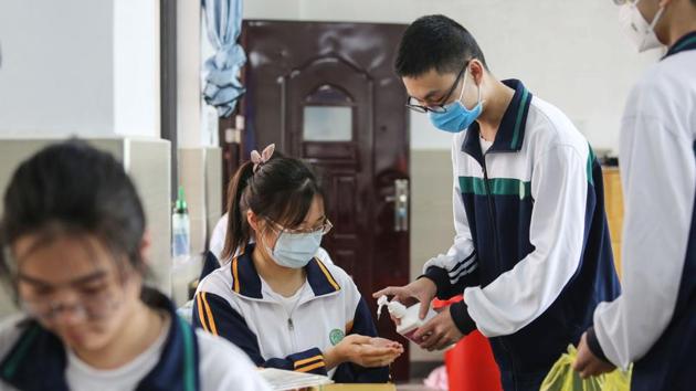 A high school senior student (R) disinfects hands for a classmate . Wednesday’s back-to-school was the latest step in a gradual normalising of life in Wuhan and surrounding Hubei province. (AFP) A high school senior student (R) disinfects hands for a classmate . Wednesday’s back-to-school was the latest step in a gradual normalising of life in Wuhan and surrounding Hubei province. (AFP)