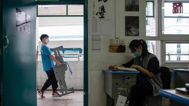 A senior student (L) transfers desk and chair at a high school. The city, where the coronavirus appeared late last year before spreading around the world, was locked down for 76 days and only reopened last month. (AFP) A senior student (L) transfers desk and chair at a high school. The city, where the coronavirus appeared late last year before spreading around the world, was locked down for 76 days and only reopened last month. (AFP)