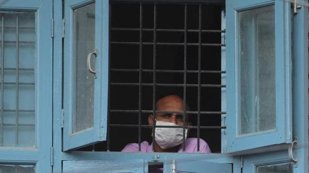 A resident looks out from a window during nationwide lockdown to check the spread of coronavirus in India.(Yogendra Kumar/HT PHOTO)