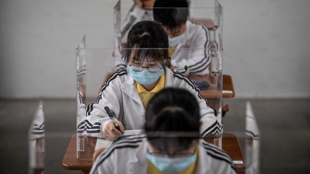 High school senior students study with plastic partitions in a classroom in Wuhan in China's central Hubei province on May 6, 2020 (AFP) High school senior students study with plastic partitions in a classroom in Wuhan in China's central Hubei province on May 6, 2020 (AFP)