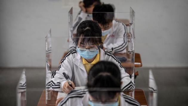 High school senior students study with plastic partitions in a classroom in Wuhan in China's central Hubei province on May 6. Senior school students in 121 institutions were back in front of chalk boards and digital displays for the first time on May 6 since their city shut down in January due to the coronavirus (COVID-19) outbreak. (STR / AFP) High school senior students study with plastic partitions in a classroom in Wuhan in China's central Hubei province on May 6. Senior school students in 121 institutions were back in front of chalk boards and digital displays for the first time on May 6 since their city shut down in January due to the coronavirus (COVID-19) outbreak. (STR / AFP)