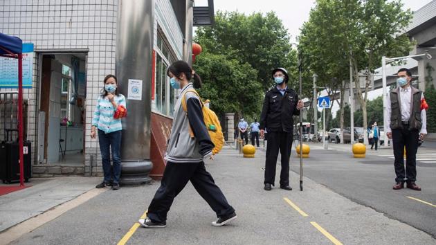 A senior student (C) enters a high school in Wuhan. State-run China Daily said some places arranged staggered arrival times for teachers and students, reported AFP. (AFP) A senior student (C) enters a high school in Wuhan. State-run China Daily said some places arranged staggered arrival times for teachers and students, reported AFP. (AFP)