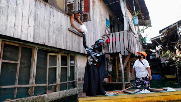 A village officer dressed as the Star Wars character Darth Vader rides a small boat to deliver relief goods to residents in the flooded Artex Compound in Malabon, Metro Manila, Philippines. (REUTERS) A village officer dressed as the Star Wars character Darth Vader rides a small boat to deliver relief goods to residents in the flooded Artex Compound in Malabon, Metro Manila, Philippines. (REUTERS)
