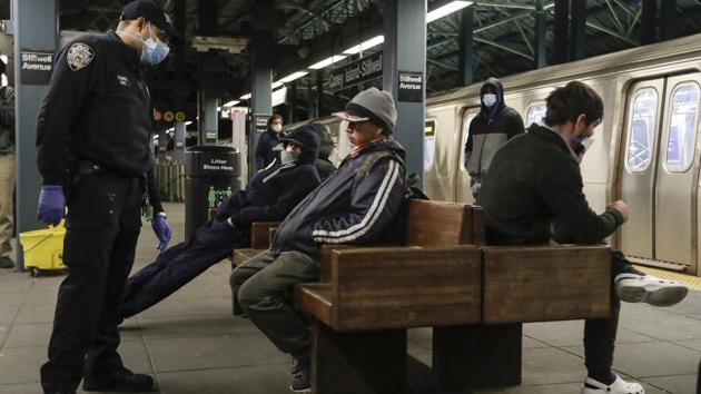 New York Police officers talk to people on the platform while MTA officials work on trains for the disinfecting operations at the Coney Island, Stillwell Terminal on May 6. Even as subway ridership has plunged more than 90%, the city’s homeless have occupied the system, largely out of fear of contracting the virus in shelters. (Frank Franklin II / AP)