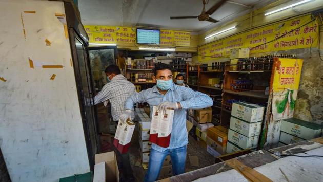 New Delhi: A shopkeeper sells liquor after authorities allowed sale of liquor with certain restrictions, during the ongoing COVID-19 nationwide lockdown, at Chander Nagar in East Delhi, Monday, May 4, 2020. (PTI) New Delhi: A shopkeeper sells liquor after authorities allowed sale of liquor with certain restrictions, during the ongoing COVID-19 nationwide lockdown, at Chander Nagar in East Delhi, Monday, May 4, 2020. (PTI)