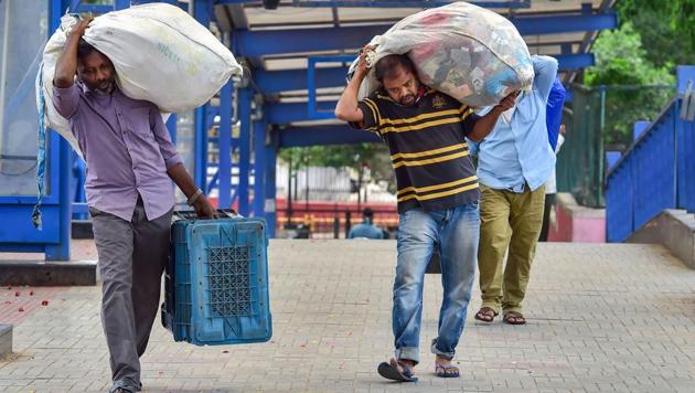 Migrants with their belongings arrive at a bus stand in Bengaluru to board a bus to reach their native places, during the ongoing nationwide lockdown imposed in the wake of coronavirus pandemic. (PTI Photo) Migrants with their belongings arrive at a bus stand in Bengaluru to board a bus to reach their native places, during the ongoing nationwide lockdown imposed in the wake of coronavirus pandemic. (PTI Photo)