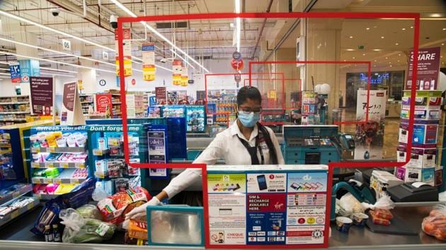 Cashier Valancy Fernandes of India, wearing a surgical mask and gloves to help prevent the spread of coronavirus, works at a Carrefour supermarket in Dubai, United Arab Emirates.(AP)