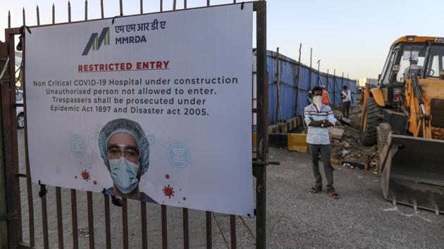 A sign is displayed on a gate at the construction site of a 1000 bed non-critical hospital for COVID-19 treatment at the Bandra Kurla Complex exhibition ground in Mumbai, India, on Wednesday, May 6. (Dhiraj Singh / Bloomberg) A sign is displayed on a gate at the construction site of a 1000 bed non-critical hospital for COVID-19 treatment at the Bandra Kurla Complex exhibition ground in Mumbai, India, on Wednesday, May 6. (Dhiraj Singh / Bloomberg)