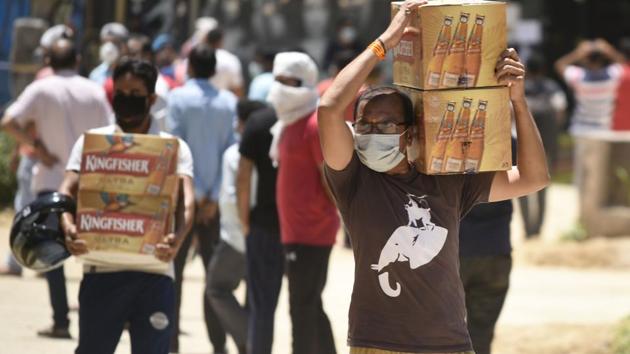 A man carries carton of alcohol bottles outside a liquor shop during lockdown to curb the spread of coronavirus pandemic. (Photo by Parveen Kumar/Hindustan Times) A man carries carton of alcohol bottles outside a liquor shop during lockdown to curb the spread of coronavirus pandemic. (Photo by Parveen Kumar/Hindustan Times)