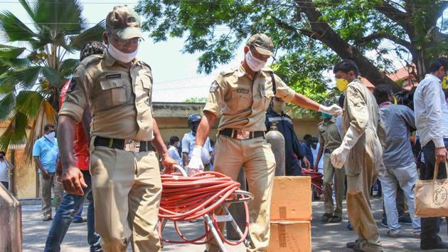 Police carry equipments after a styrene vapour leak from a polymer plant in Visakhapatnam.(PTI Photo)