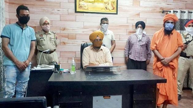 The dera head (in saffron clothes) and his followers in the custody of special task force in Ludhiana on Friday. (HT Photo) The dera head (in saffron clothes) and his followers in the custody of special task force in Ludhiana on Friday. (HT Photo)