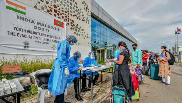High Commission officials and volunteers wearing PPE screen Indian citizens going to the Velana International Airport for visa procedures before boarding the INS Jalashwa ship to be evacuated to India, at the Greater Male bus station, in Male. (Ahmed Shurau / AFP) High Commission officials and volunteers wearing PPE screen Indian citizens going to the Velana International Airport for visa procedures before boarding the INS Jalashwa ship to be evacuated to India, at the Greater Male bus station, in Male. (Ahmed Shurau / AFP)