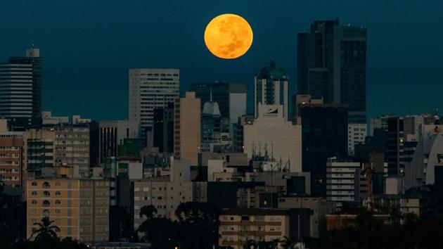 The Flower Super Moon rises over Curitiba, Brazil on May 7. The term “supermoon” was coined by astrologer Richard Nolle in 1979 and refers to either a new or a full moon that occurs within 90% of perigee. (Daniel Castellano / AFP) The Flower Super Moon rises over Curitiba, Brazil on May 7. The term “supermoon” was coined by astrologer Richard Nolle in 1979 and refers to either a new or a full moon that occurs within 90% of perigee. (Daniel Castellano / AFP)