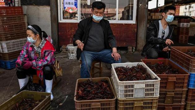 This photo taken on April 15, 2020 shows vendors wearing face masks as they offer prawns for sale at the Wuhan Baishazhou Market in Wuhan in China's central Hubei province. (AFP) This photo taken on April 15, 2020 shows vendors wearing face masks as they offer prawns for sale at the Wuhan Baishazhou Market in Wuhan in China's central Hubei province. (AFP)
