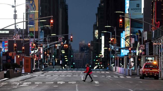 A woman walks through an almost-deserted Times Square in the early morning hours on April 23, 2020 in New York City.(AFP)
