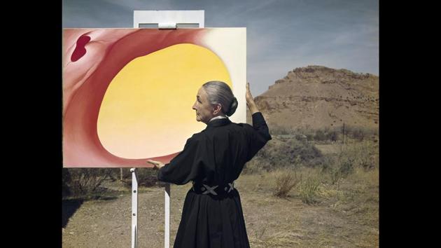 This 1960 photograph by Vacarro shows artist Georgia O'Keeffe posing with her painting "Pelvis Series, Red with Yellow" in Taos Pueblo, New Mexico. After WWII, Vaccaro documented the reconstruction of Europe and returned to the US where he worked for magazines such as Look and Life. (Tony Vaccaro via AP)