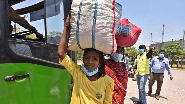 Migrant workers at Delhi’s Yamuna Sports Complex board a transit bus which will ferry them to a Shramik Special train headed for Bihar on Friday.(Raj K Raj/HT PHOTO)