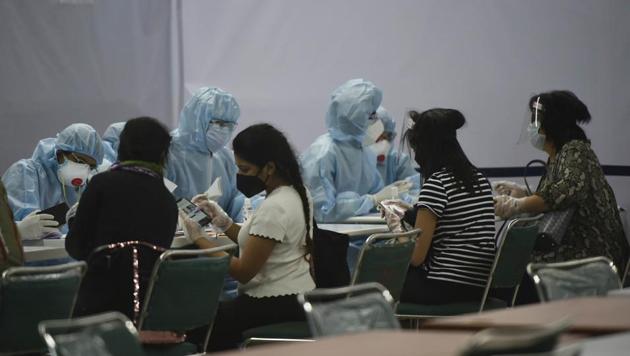 Medical staff in PPE overalls hand out medical advisories to Indians evacuees from Singapore and Dhaka at Terminal 3, Indira Gandhi International Airport, New Delhi on Friday. (Vipin Kumar/HT PHOTO) Medical staff in PPE overalls hand out medical advisories to Indians evacuees from Singapore and Dhaka at Terminal 3, Indira Gandhi International Airport, New Delhi on Friday. (Vipin Kumar/HT PHOTO)