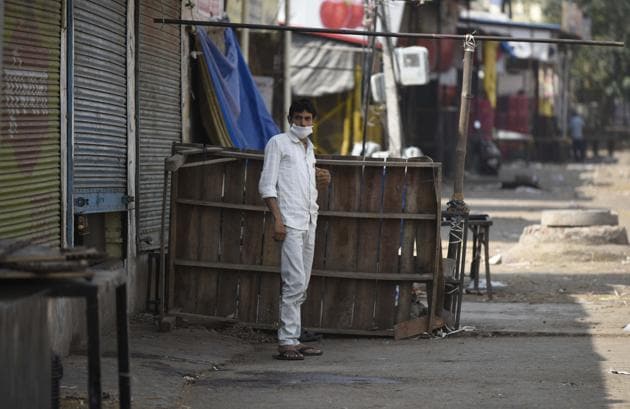 A man in a face mask stands next to shuttered shops in the Khandsa Mandi, in Gurugram. (Parveen Kumar/Hindustan Times) A man in a face mask stands next to shuttered shops in the Khandsa Mandi, in Gurugram. (Parveen Kumar/Hindustan Times)