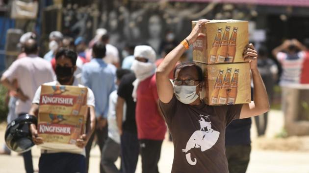 A man carries carton of alcohol bottles outside a liquor shop during lockdown to curb the spread of coronavirus pandemic, at Sector 40, near Huda Market, in Gurugram.(Parveen Kumar/Hindustan Times) A man carries carton of alcohol bottles outside a liquor shop during lockdown to curb the spread of coronavirus pandemic, at Sector 40, near Huda Market, in Gurugram.(Parveen Kumar/Hindustan Times)