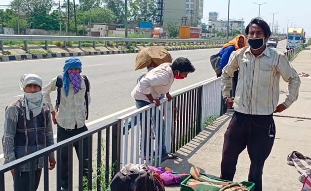 Migrants crossing the highway near Dhandari Kalan in Ludhiana to continue their 900km journey from Amritsar to Auraiya in Uttar Pradesh on Friday. (Gurpreet ingh/HT) Migrants crossing the highway near Dhandari Kalan in Ludhiana to continue their 900km journey from Amritsar to Auraiya in Uttar Pradesh on Friday. (Gurpreet ingh/HT)