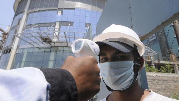 A worker undergoes thermal screening at an under construction site during lockdown, at at Supertech Supernova, Sector 94. (Sunil Ghosh / Hindustan Times) A worker undergoes thermal screening at an under construction site during lockdown, at at Supertech Supernova, Sector 94. (Sunil Ghosh / Hindustan Times)