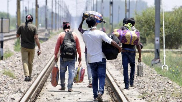 Migrants walking to their homes along a railway track in Greater Noida on Friday.(Sunil Ghosh/HT Photo)