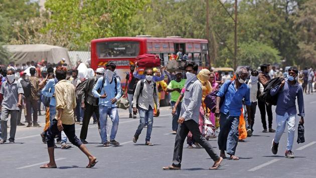 Stranded migrant workers in Gujarat’s Ahmedabad arrive to board buses that will take them to railway station then their home states of Bihar, Uttar Pradesh and Rajasthan during the Covid-19 lockdown on Friday. (ANI Photo)