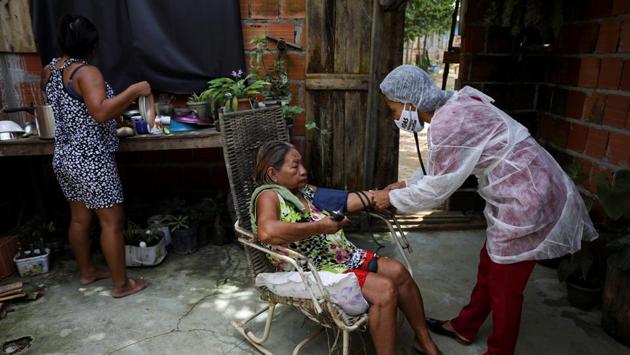 Vanda examines her patient Apolonia Antonia Martins Bare, in Manaus. Vanda was born in the river village of Amatura and moved down river ten years ago to Manaus, where she trained as a nurse technician. She works treating skin cancer patients at a clinic in the city. (Bruno Kelly / REUTERS) Vanda examines her patient Apolonia Antonia Martins Bare, in Manaus. Vanda was born in the river village of Amatura and moved down river ten years ago to Manaus, where she trained as a nurse technician. She works treating skin cancer patients at a clinic in the city. (Bruno Kelly / REUTERS)