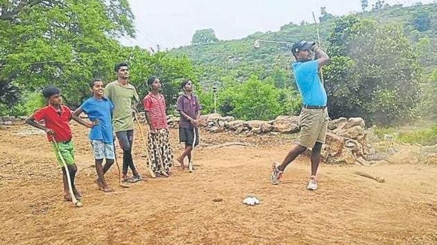 C Muniyappa is watched by, among others, his two sons and a daughter as he goes for a shot and (above) one of the two par-3 holes the Indian Open champ has meticulously built.(HT Photo)