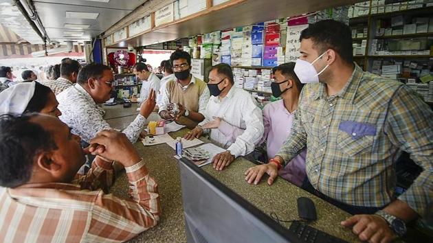 Salesmen at a chemist shop wear protective masks in wake of the deadly novel coronavirus. (PTI photo) Salesmen at a chemist shop wear protective masks in wake of the deadly novel coronavirus. (PTI photo)
