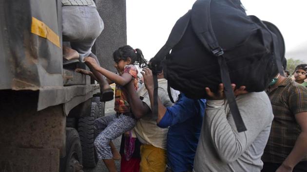 A small girl is pushed into a truck by her father at the Eastern express highway between Thane and Bhiwandi in the wee hours of the morning on May 9. The covid-19 pandemic has hit the poor the hardest in India, with locked factories and other workplaces triggering the biggest internal migration since Partition, according to a report in Mint. (Satish Bate / HT Photo) A small girl is pushed into a truck by her father at the Eastern express highway between Thane and Bhiwandi in the wee hours of the morning on May 9. The covid-19 pandemic has hit the poor the hardest in India, with locked factories and other workplaces triggering the biggest internal migration since Partition, according to a report in Mint. (Satish Bate / HT Photo)