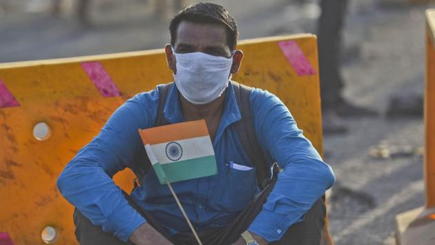 A worker holding the Indian flag, catching a break on the Eastern Express Highway during his walk home to his village in Uttar Pradesh. The issue of migration has snowballed into a political one amid chaotic scenes from across the country. (Satish Bate / HT Photo) A worker holding the Indian flag, catching a break on the Eastern Express Highway during his walk home to his village in Uttar Pradesh. The issue of migration has snowballed into a political one amid chaotic scenes from across the country. (Satish Bate / HT Photo)