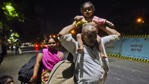A family walks well into the night from Ghatkopar towards their village in Uttar Pradesh on May 8. Many workers have been detained from trying to cross inter-state borders; some have tried to cross over through forests that span two states; others have tried to use boats to cross rivers. (Satish Bate / HT Photo) A family walks well into the night from Ghatkopar towards their village in Uttar Pradesh on May 8. Many workers have been detained from trying to cross inter-state borders; some have tried to cross over through forests that span two states; others have tried to use boats to cross rivers. (Satish Bate / HT Photo)