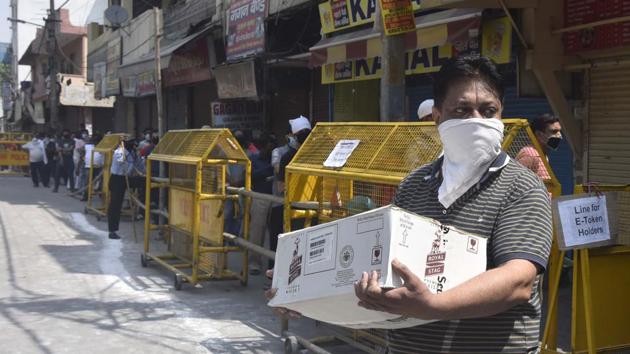 A man seen with a crate of alcohol bottles outside a liquor during lockdown in Jheel Chowk, New Delhi on Saturday. (Sonu Mehta/HT PHOTO) A man seen with a crate of alcohol bottles outside a liquor during lockdown in Jheel Chowk, New Delhi on Saturday. (Sonu Mehta/HT PHOTO)