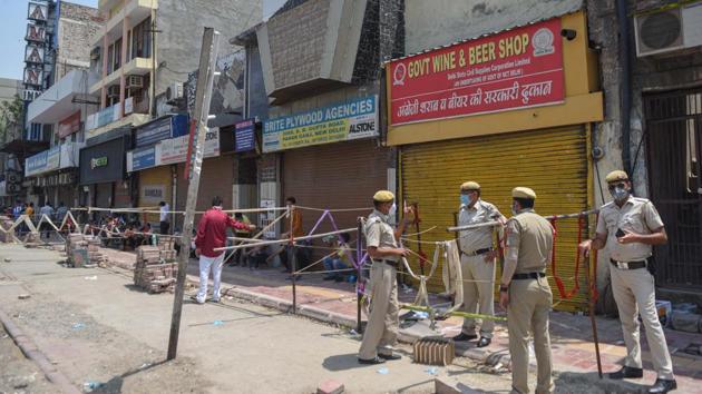 Police personnel stand guard near a liquor shop, during lockdown at Paharganj in New Delhi. (Sanchit Khanna/HT Photo) Police personnel stand guard near a liquor shop, during lockdown at Paharganj in New Delhi. (Sanchit Khanna/HT Photo)