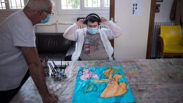 Alain (L), an educator and art therapist, works with Yago, at the Santos-Dumont day mental hospital of the Elan Retrouve association. (Loic Venance / AFP)