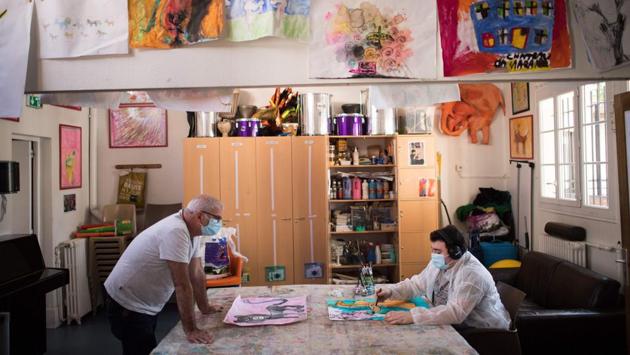 Alain speaks to Yago during a workshop in Santos-Dumont day mental hospital. The instructors can mould established routines and activities to the restrictions of the pandemic. (Loic Venance / AFP)
