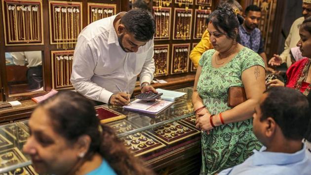 Customers browse gold jewellery as an employee writes on a counter inside the Zaveri Kapoorchand Lalchand jewellery store in Mumbai. (Bloomberg File Photo) Customers browse gold jewellery as an employee writes on a counter inside the Zaveri Kapoorchand Lalchand jewellery store in Mumbai. (Bloomberg File Photo)