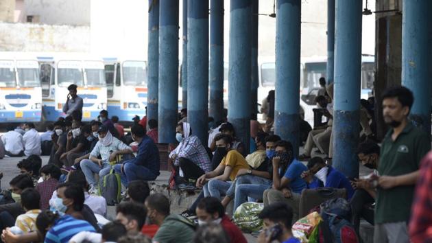 Stranded migrant workers wait for buses bound to their native state – Uttarakhand in Gurugram.(Parveen Kumar/HT PHOTO)