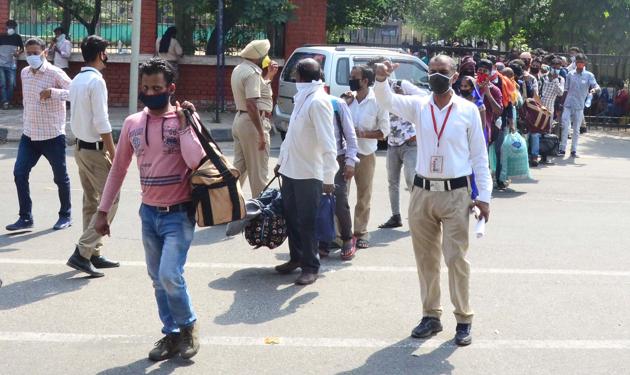 Migrant workers from Uttar Pradesh and Bihar queue up for screening before boarding trains to their respective states, in Ludhiana, on Sunday. (Gurpreet Singh) Migrant workers from Uttar Pradesh and Bihar queue up for screening before boarding trains to their respective states, in Ludhiana, on Sunday. (Gurpreet Singh)